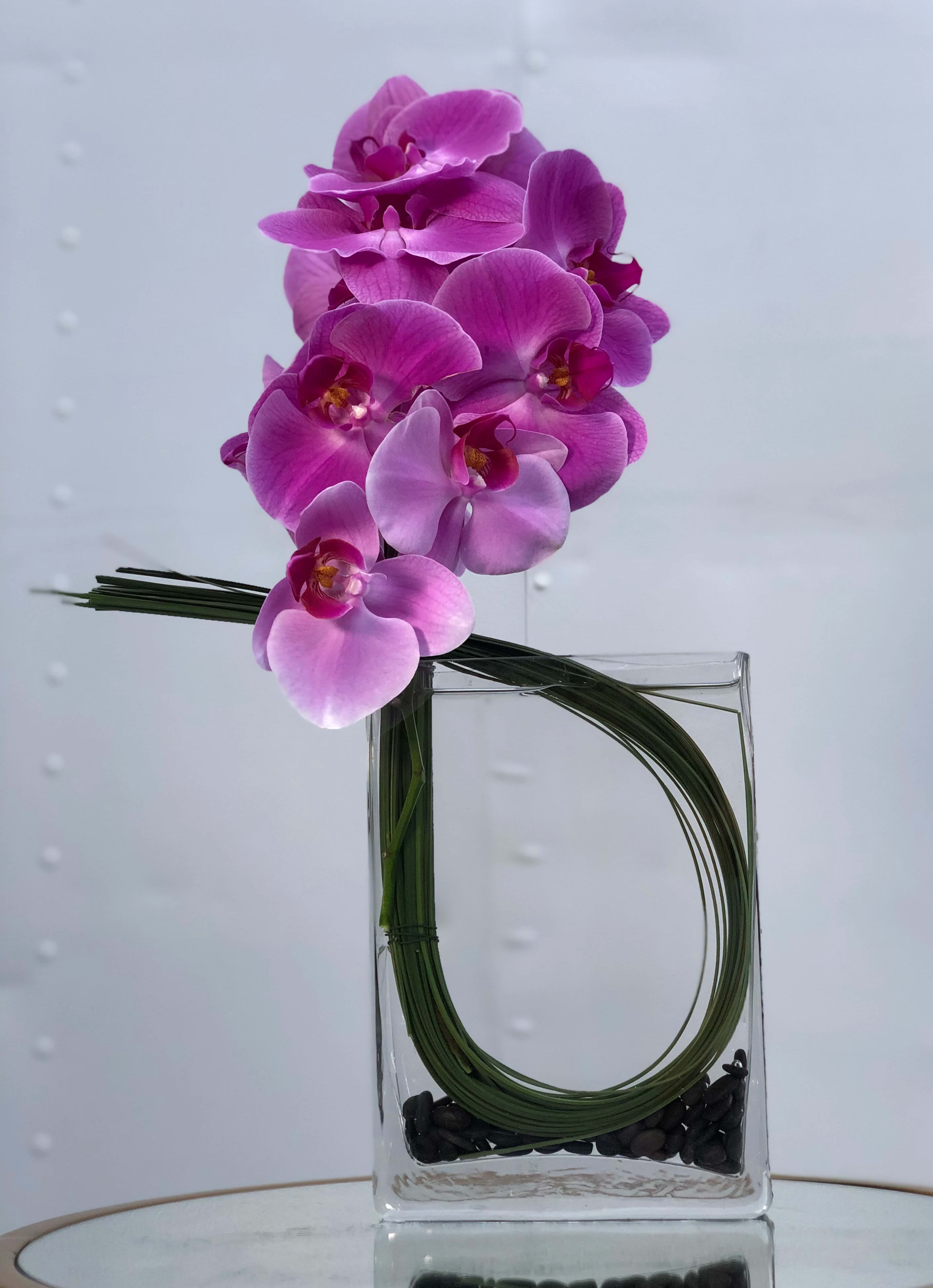 Magenta Kado - A chic, minimalist arrangement of purple Phalaenopsis Orchids and Flexi Grass