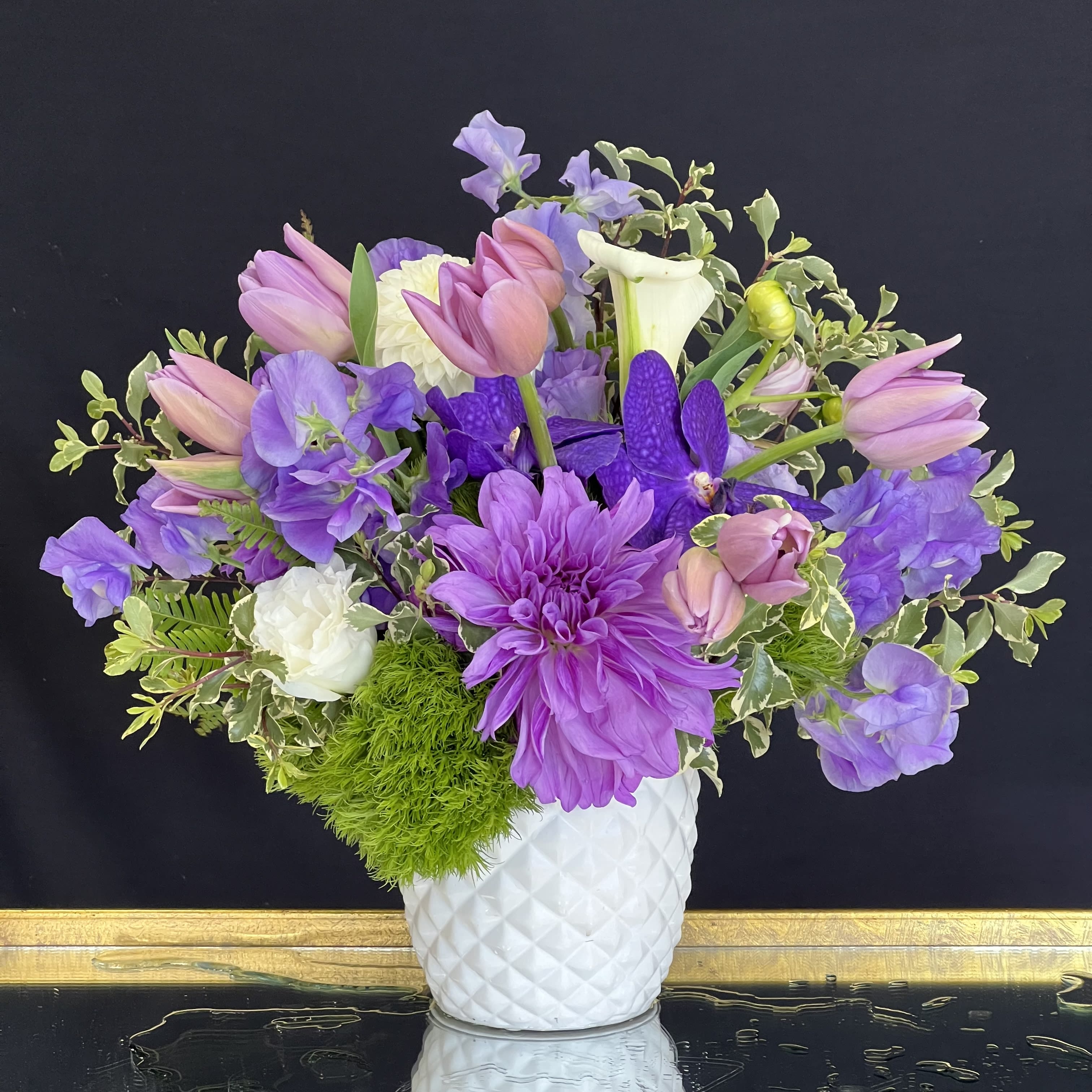 Osmalin  - Shades of purple come together in this sweet garden arrangement, featuring Dahlias, Tulips, Dianthus, and Orchids