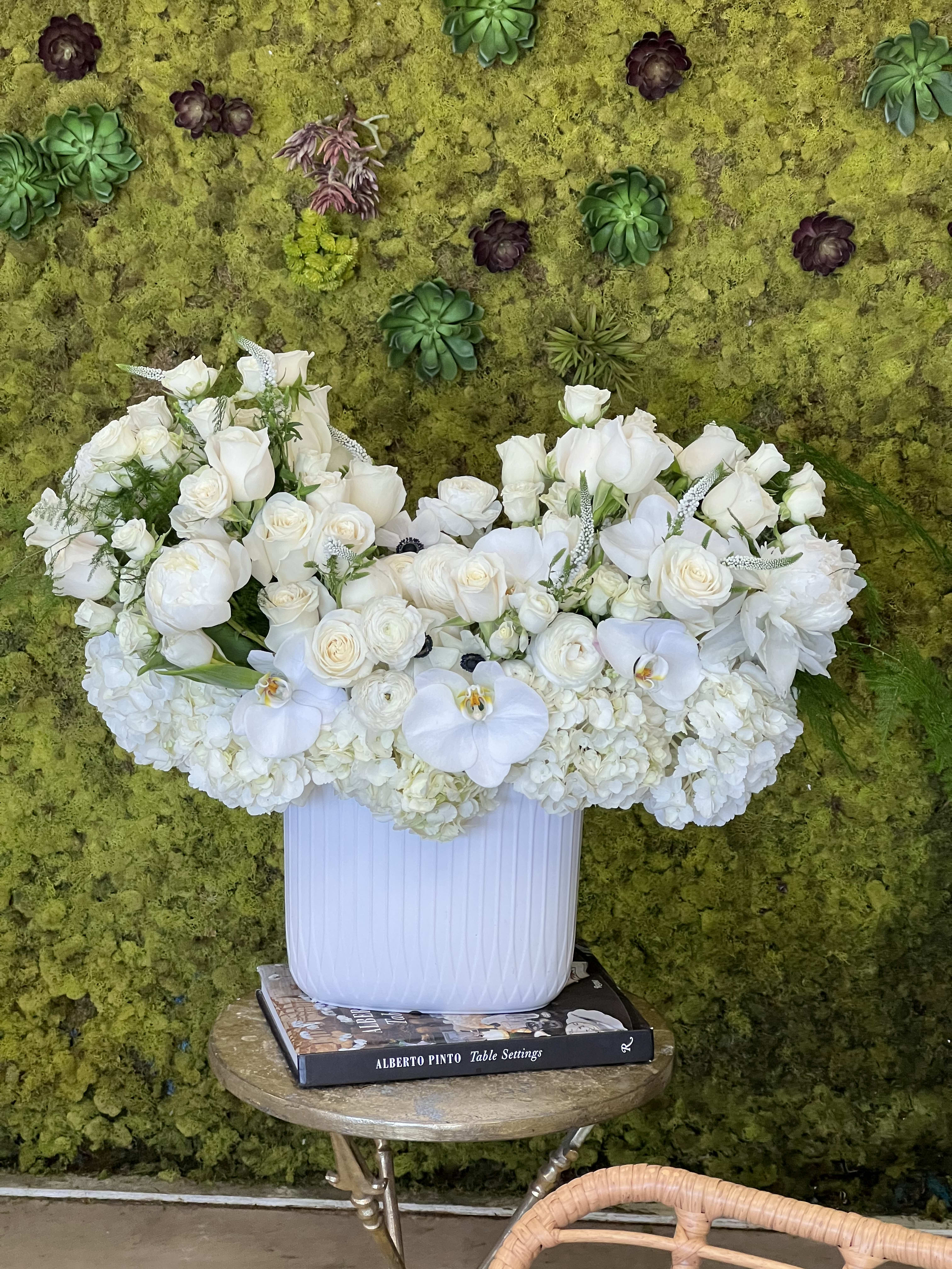 Pure Elegance - A beautiful collection of luxurious white blooms in a stylish white ceramic vase. Featuring Hydrangea, Roses, Peonies, Phalaenopsis Orchids, and Veronica