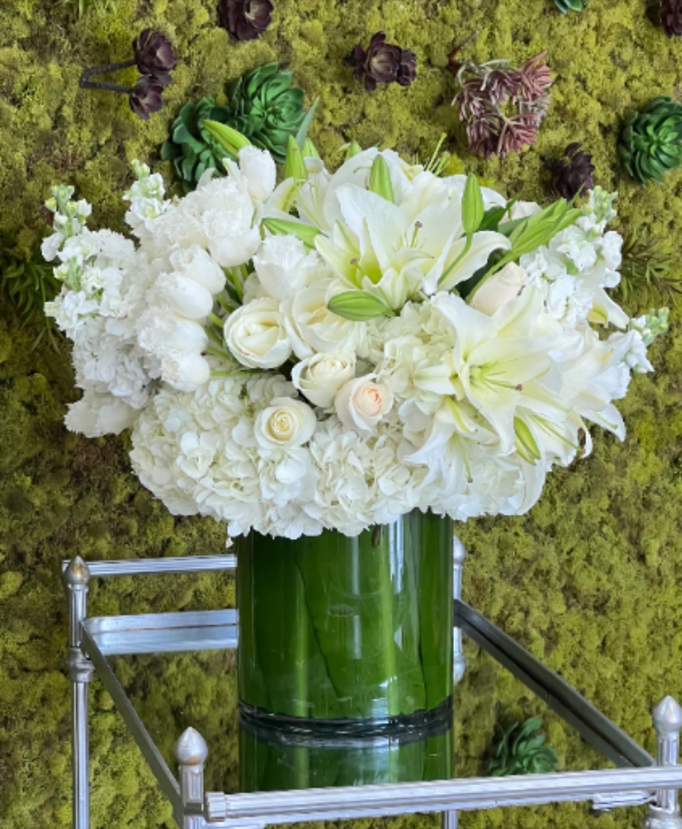 In My Heart  - This elegant white arrangement comprises Roses, Tulips, Lilies, Stock, and Hydrangea, beautifully arranged in a leaf-lined large cylinder vase