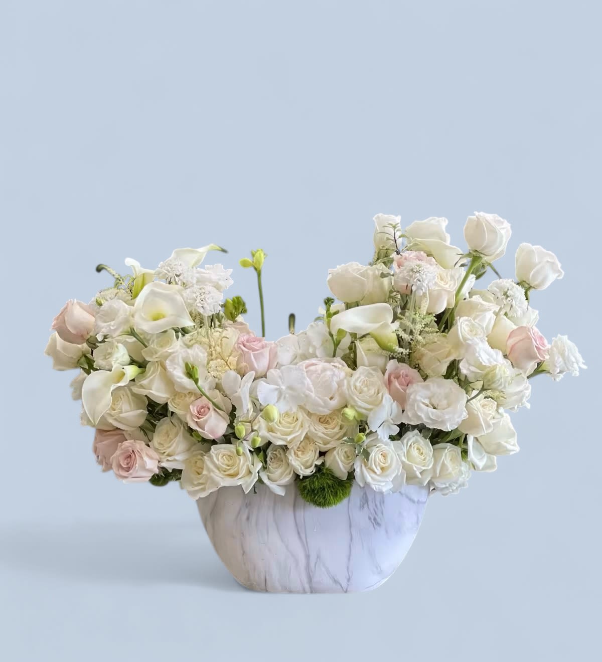 Emi - A pretty white and blush arrangement filled with Roses, Spray Roses, Lisianthus, Calla Lilies, Dendrobium Orchids, and other soft blooms