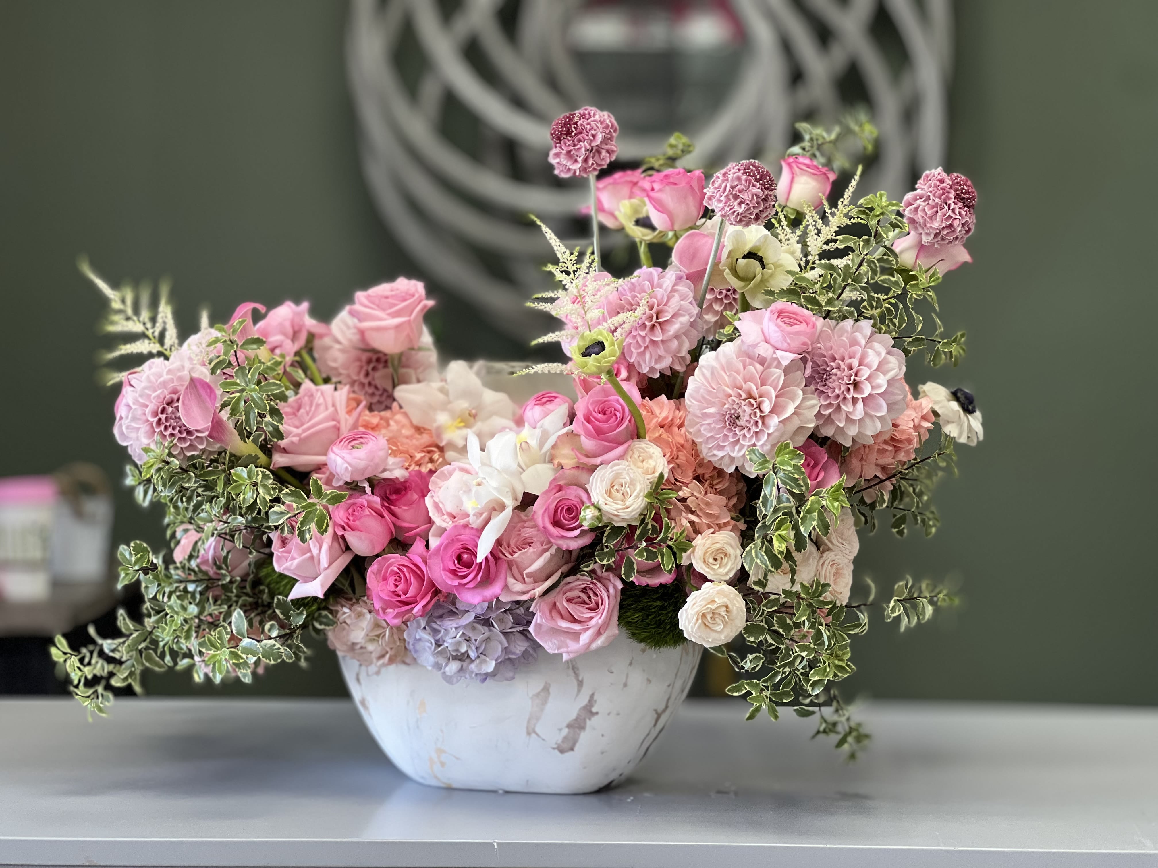 Carmela  - Soft pink Roses, Spray Roses, Ranunculus, Anemones, Dahlias, Calla Lilies, and Hydrangea in a ceramic container
