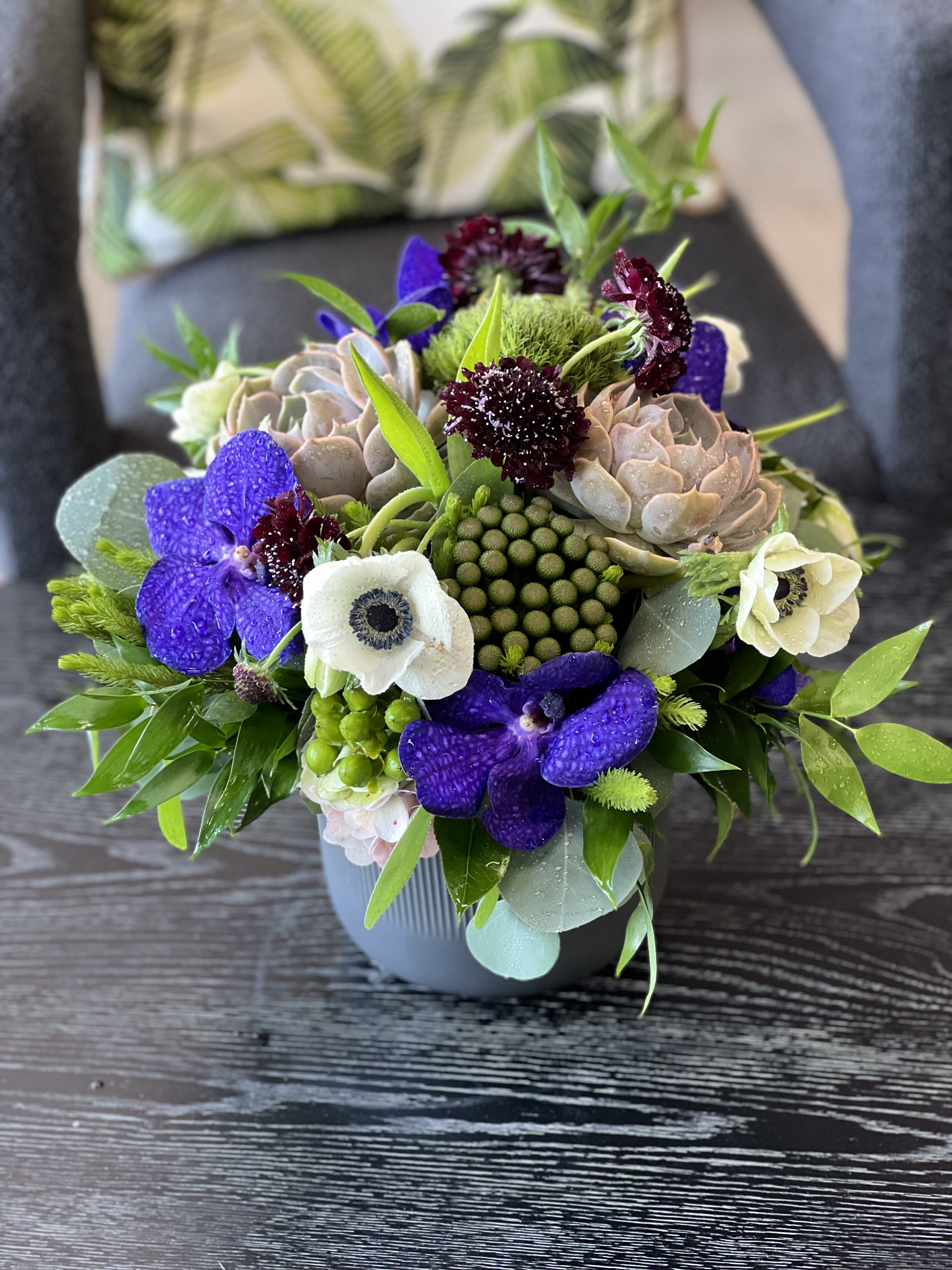 Anastasia - This luscious ceramic vase arrangement features Vanda Orchids, Scabiosa, Anemones, Succulents, and mixed greenery