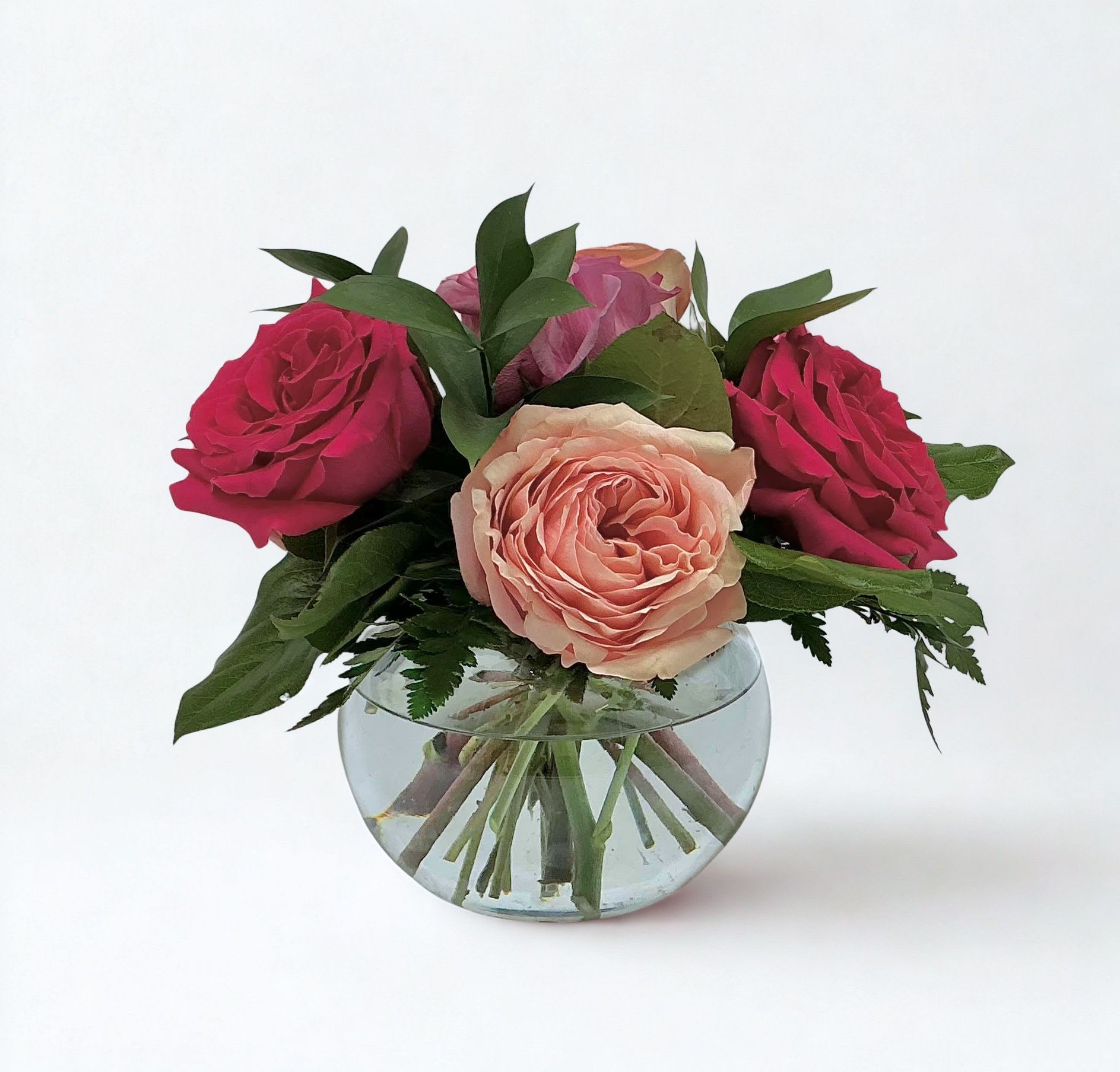 Half-Dozen Rainbow Roses - This Mother's Day Special is here for a limited time only! The arrangement showcases a vibrant blend of garden roses, artfully gathered in a low-profile container for a look that feels both polished and inviting. Each Half-Dozen Rainbow Roses is uniquely curated, with colors varying based on the freshest selections available—making every arrangement a one-of-a-kind experience.