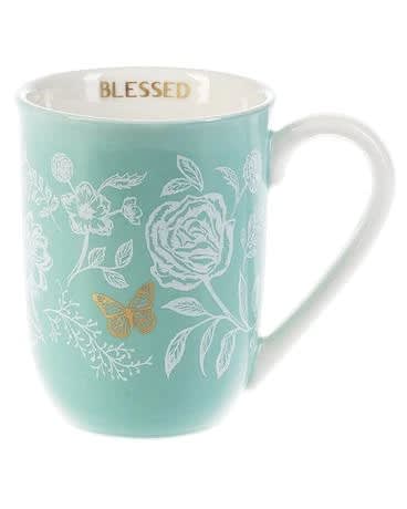 Mint blue ceramic mug with white floral design, gold butterfly, and 'Blessed' printed inside the rim