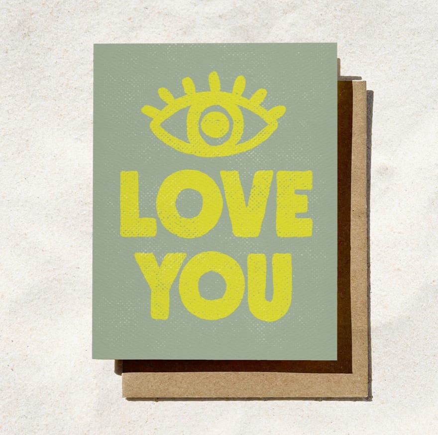 A greeting card with a yellow eye icon and the words LOVE YOU
