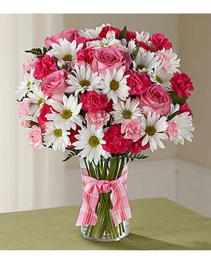 Pink roses, pink carnations, and white daisies in a clear vase with a pink plaid bow.