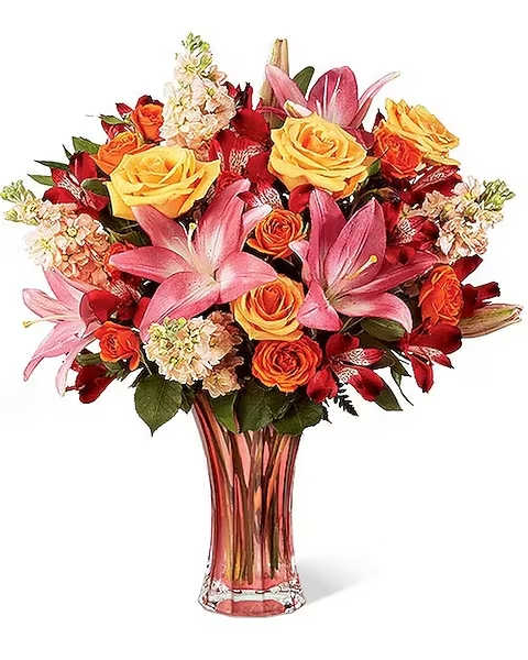 Touch Of Spring - The Touch of Spring Bouquet beautifully delivers the season's exuberant, sunlit promise. Lovely peach colored roses, pink Asiatic Lilies, fragrant peach gilly flower, red Peruvian Lilies, orange spray roses and lush greens combine in a refreshing bouquet arranged in a graceful peach glass keepsake vase. Makes a perfect gift for Easter, Mother's Day, graduation or to say, "thank you!" 