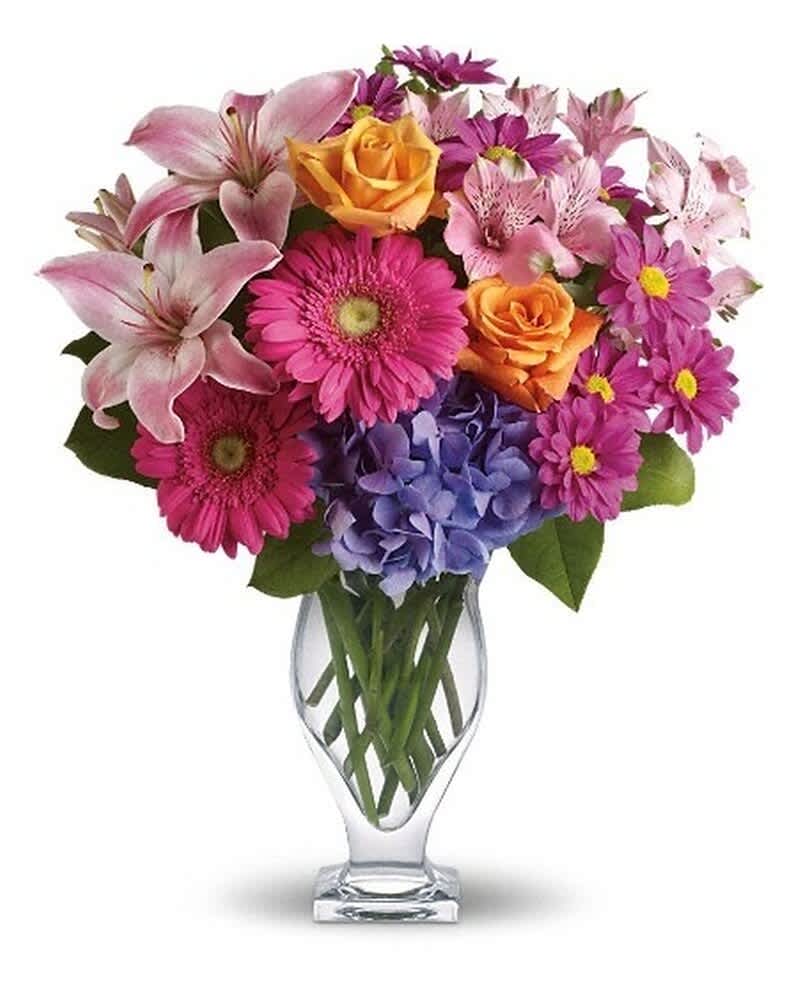Bright mixed bouquet of pink, orange, and purple flowers in a clear glass vase