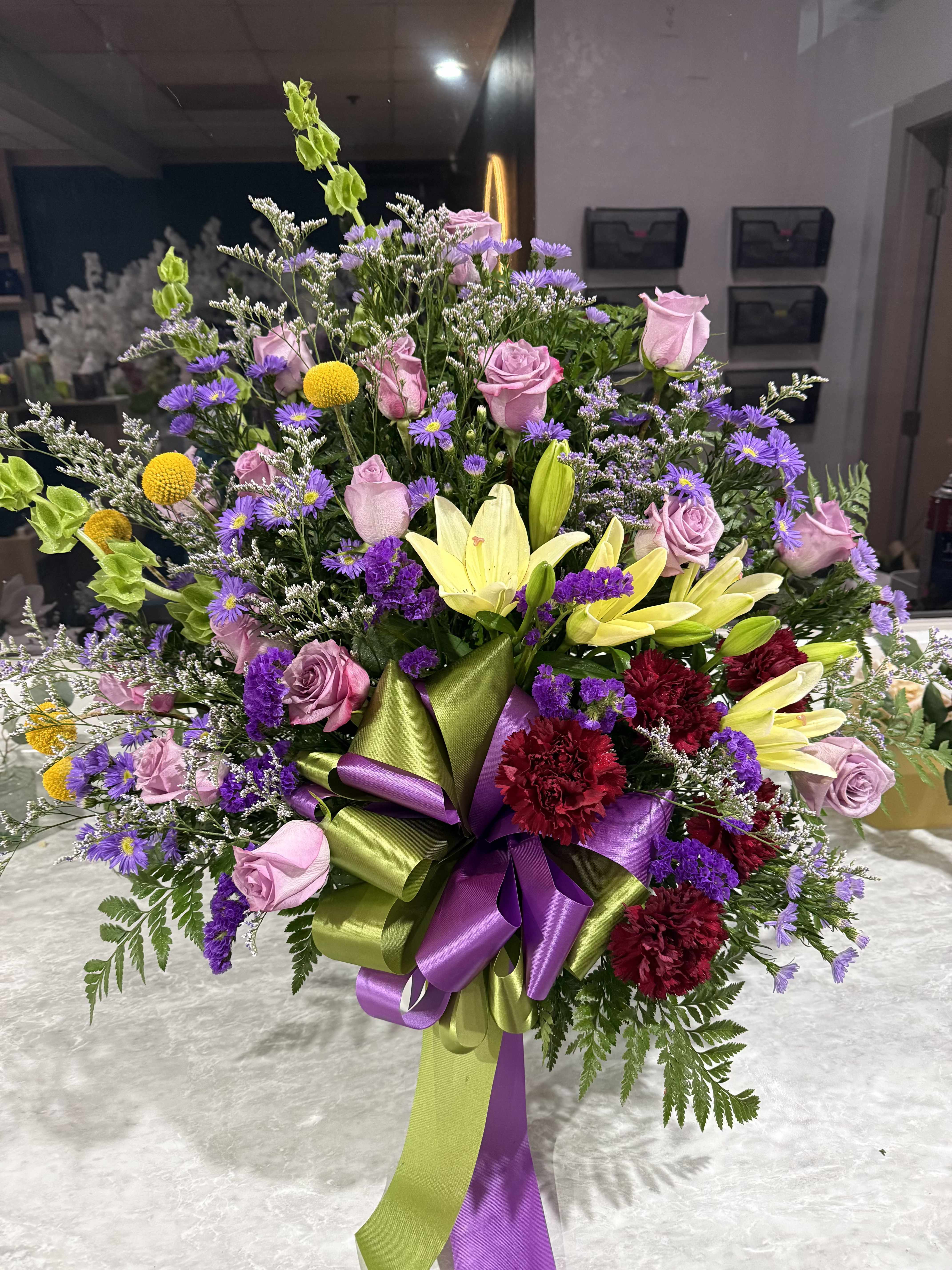 Lavender Peace Basket - A soft and comforting arrangement of lavender and white flowers, symbolizing peace, grace, and remembrance. Designed in a basket with gentle greenery for a calm, elegant tribute.
