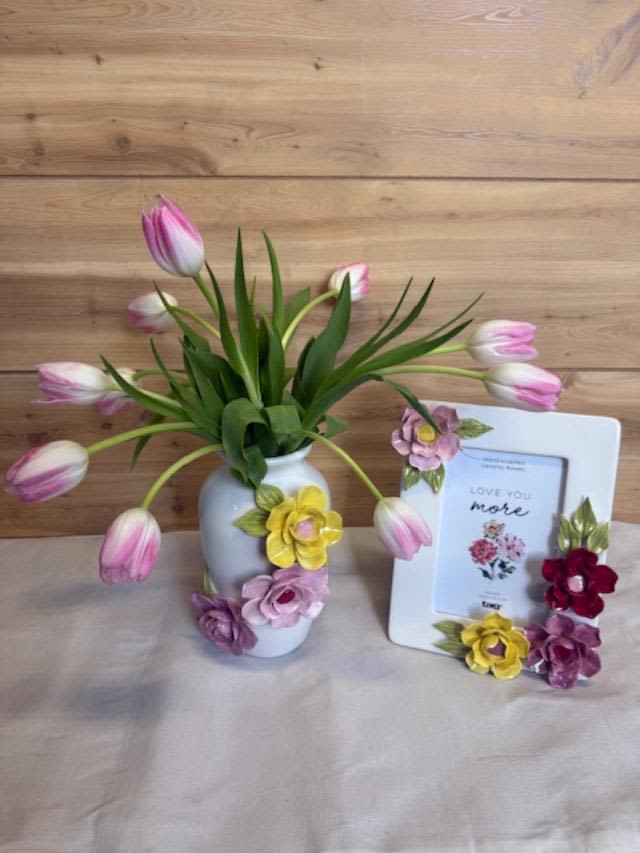 Picture Perfect - Soft assorted tulips arching from a glossy white ceramic vase give this picture-perfect arrangement a for Mom or any other cherished woman in your life.  Perfect for home display, the ensemble warms a mantel, bedside table, or entry console with pastel charm and heartfelt intention - she'll feel genuinely seen and cherished. The arrangement arrives ready to display in the sculpted white vase alongside the keepsake frame; refresh the tulips with fresh water and trim stems every few days to extend their life.