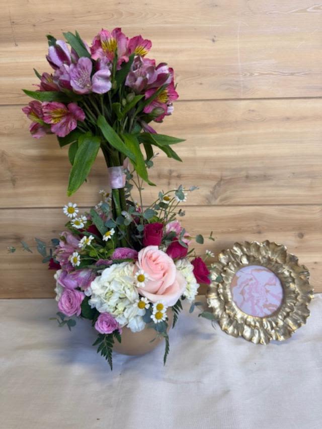 Almost Frameous - Set in a round ceramic vase, the flowers are densely arranged at the base for a full, luxurious look while the upright alstroemeria add height and movement; a neat pink ribbon secures the stems for a polished, gift-ready finish. A decorative gold picture frame with a ruffled, petal-like edge accompanies the vase, adding an elegant touch that elevates the presentation-perfect for gifting or display on a mantel or bedside table.