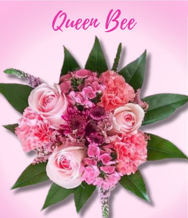 Mother's Day! Queen Bee - Wrap  - A compact, crown-like bouquet that says "you're the queen" with soft pink roses and ruffled pink carnations-perfect as a birthday bouquet, Mother's Day arrangement, or romantic gesture for the special woman in your life. The arrangement's feminine, celebratory presence makes the recipient feel cherished and seen, whether you're honoring a mom, grandmother, partner, or mentor.  The flowers are tightly clustered for a lush, full look: smooth-petaled roses paired with frilled carnations and deeper magenta filler blooms for depth and contrast, all framed by a ring of large glossy green leaves that create a star-like outline. Colors are gentle pinks and crisp whites with bright green accents that read fresh and elegant. Sized as a compact, everyday bouquet, it's designed to arrive full and ready to display; simple care-fresh water and a cool spot-will keep the blooms looking their best for days.