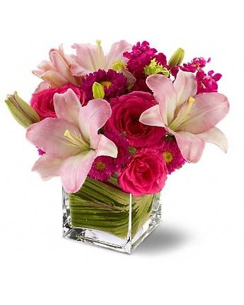Posh Pinks - A stellar floral arrangement of hot pink roses with pale pink lilies and mixed blossoms – arranged in a sparkling, modern glass cube vase lined with leaves – is pretty, posh and perfectly high-class! Send this stylish gift, and show your impeccable taste. 