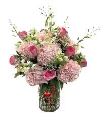 Blush &amp; Ivory Elegance Vase - A sophisticated and graceful arrangement designed with soft, romantic tones. This elegant display features lush pink hydrangeas and pink roses, complemented by white snapdragons or stock, delicate white limonium, and exotic white dendrobium orchids. Arranged in a clear glass vase, the combination of textures and colors creates a refined and timeless presentation perfect for any special occasion.