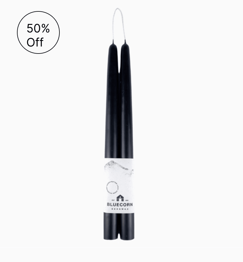 Pair of black taper candles joined by one wick with a Bluecorn label around the base