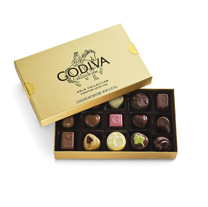 Gold box of assorted Godiva chocolates with the lid partially open
