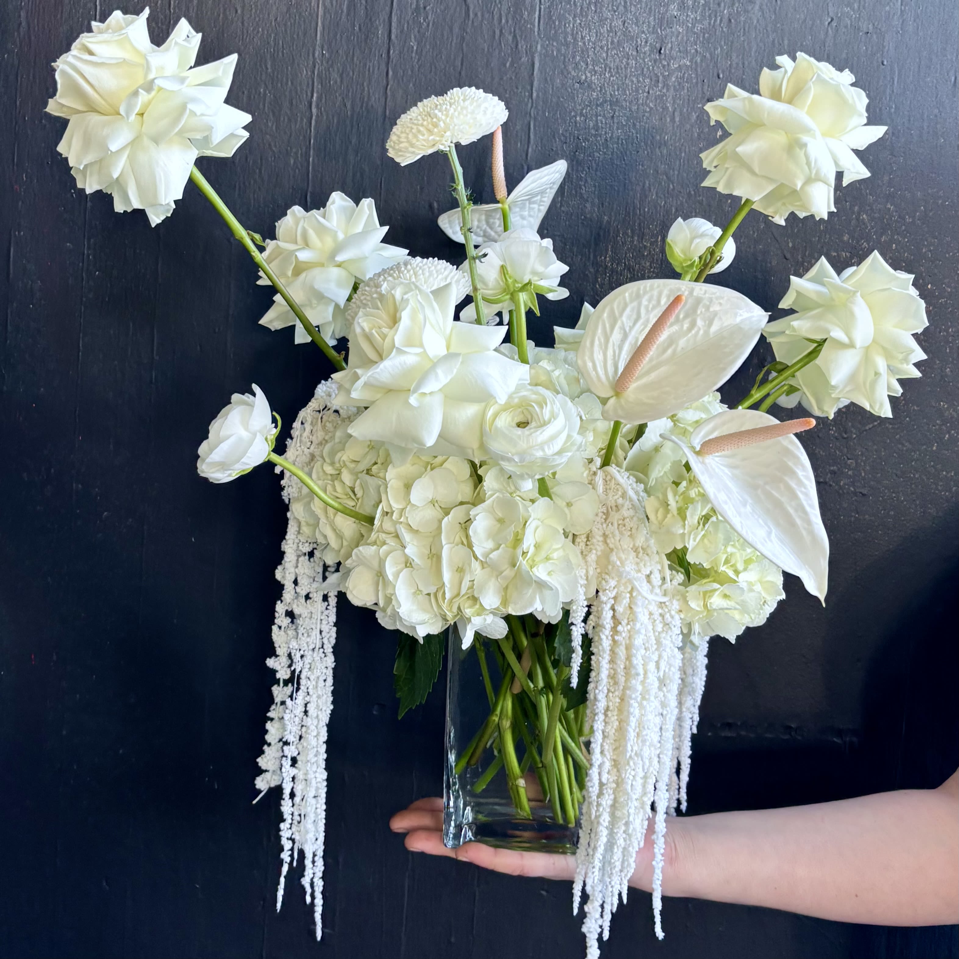 White Lace - A modern monochromatic design in white. Gorgeous white roses float on top of a landscape of soft white blossoms. Perfect arrangement for a wedding, anniversary, or sympathy. 