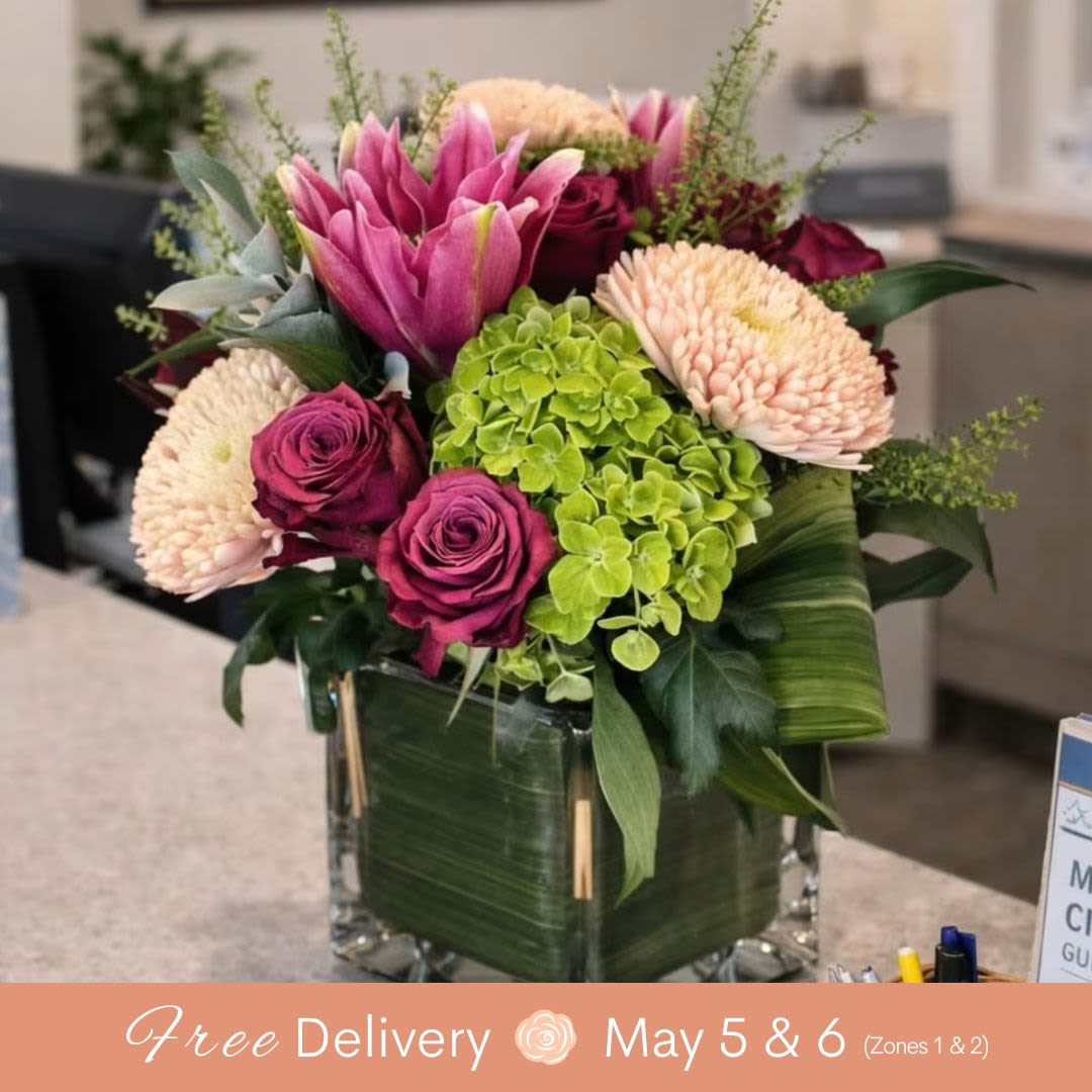 Motherly Love - Celebrate Mom with a timeless and elegant gift. Our Motherly Love floral arrangement features a gorgeous yet compact design with premium hydrangea, rose lilies, cremon, and fresh roses, all beautifully arranged in a sleek, modern contemporary vessel.  This arrangement is perfect for those looking for a Mother’s Day flower delivery that combines sophistication with a lush, full look in a manageable size. The combination of soft textures and vibrant seasonal blooms creates a balanced, eye-catching display that is ideal for homes, offices, or bedside tables.  Designed by our expert florists, each piece is crafted using the freshest available flowers to ensure quality and longevity. While colors may vary, every arrangement maintains the same premium feel and beautiful presentation.  Whether you’re sending love from near or far, this piece is a wonderful choice for anyone searching for Mother’s Day flowers, hydrangea arrangements, or modern floral gifts.   Product Details:  Includes: Hydrangea, rose lilies, cremon, roses &amp; seasonal accents  Style: Compact, modern design  Container: Contemporary vase  Occasion: Mother’s Day, appreciation, everyday gifting  Delivery: Available for local delivery and in-store pickup   Why Customers Love It:   Elegant and modern look  Premium flower combination  Perfect size for any space  Great value for a luxury arrangement