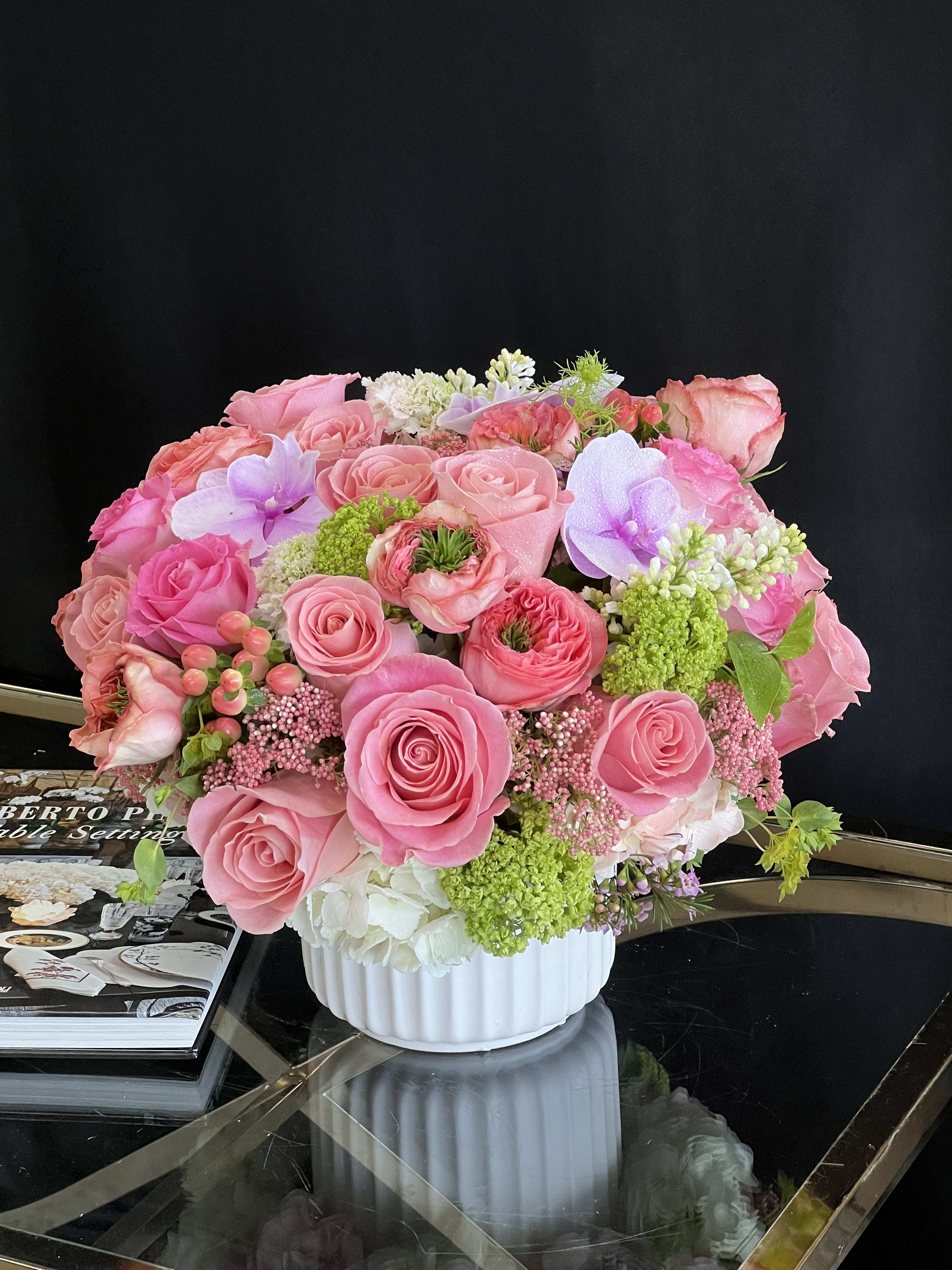 Monte Carlo - This desktop-sized floral arrangement comprises Roses, Garden Roses, Hydrangea, and Phalaenopsis Orchids in a white ceramic vase