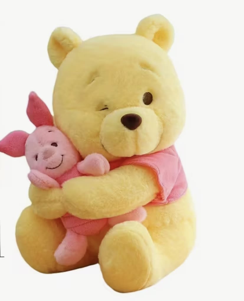 Yellow teddy bear hugging a pink pig plush toy