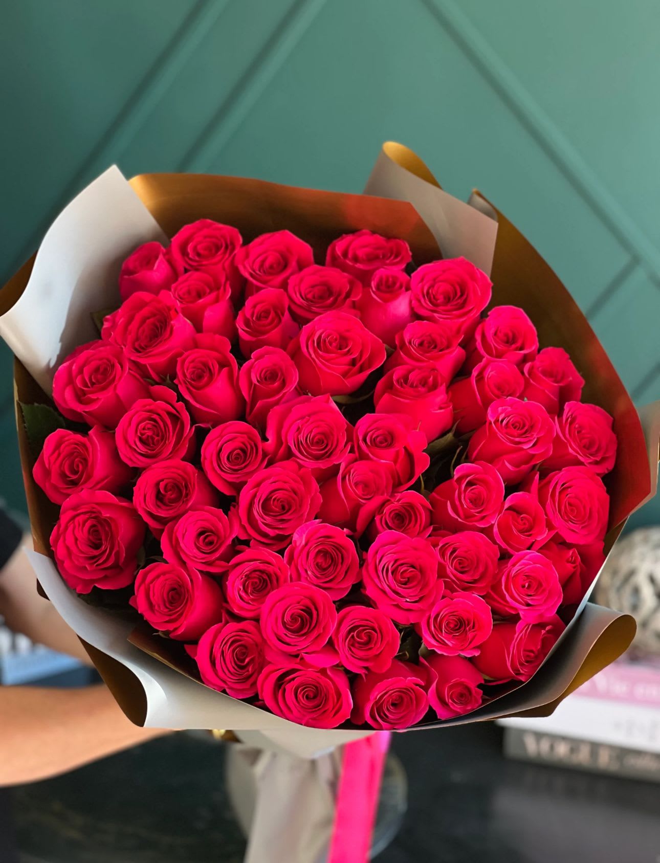 Bouquet of bright pink roses wrapped in brown and white paper
