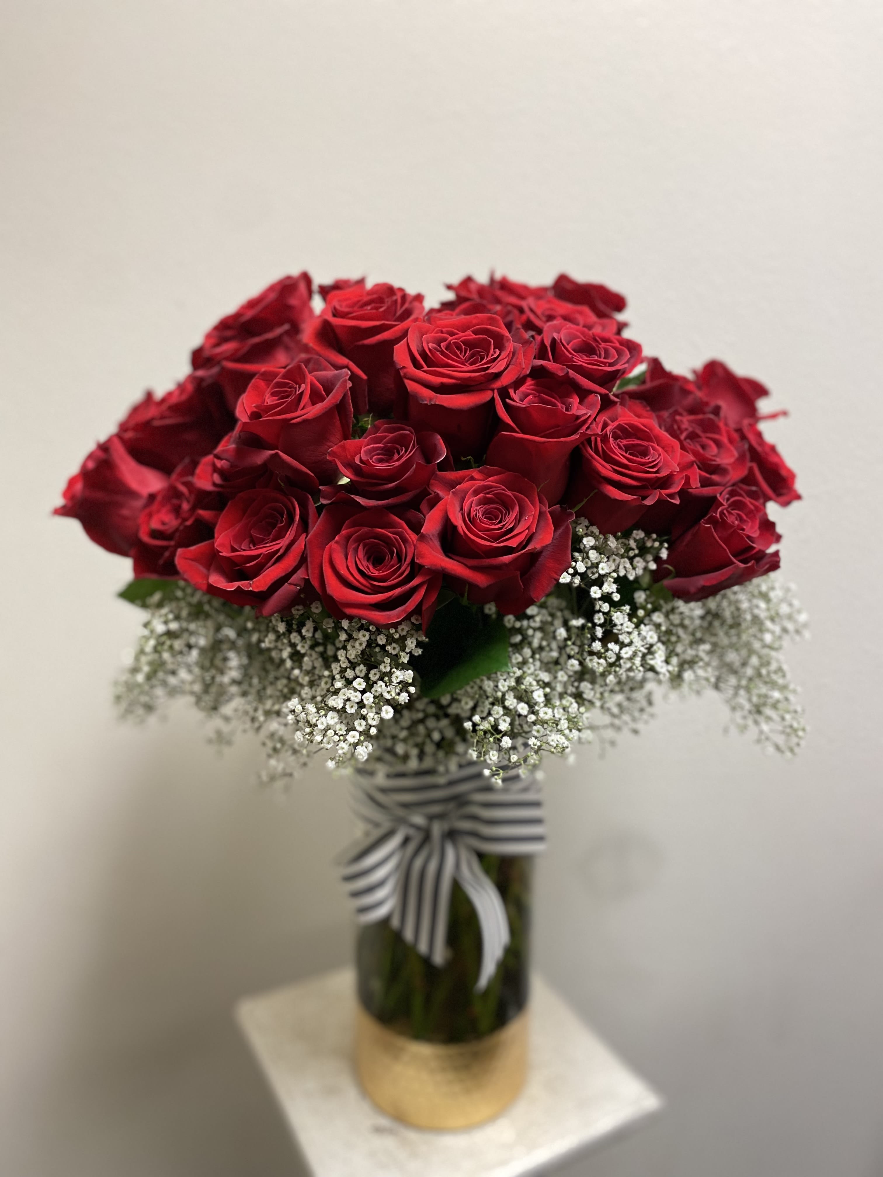 Bouquet of red roses with white baby's breath in a glass vase