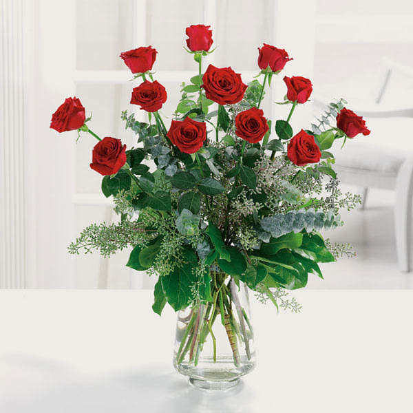 Red roses arranged in a clear glass vase