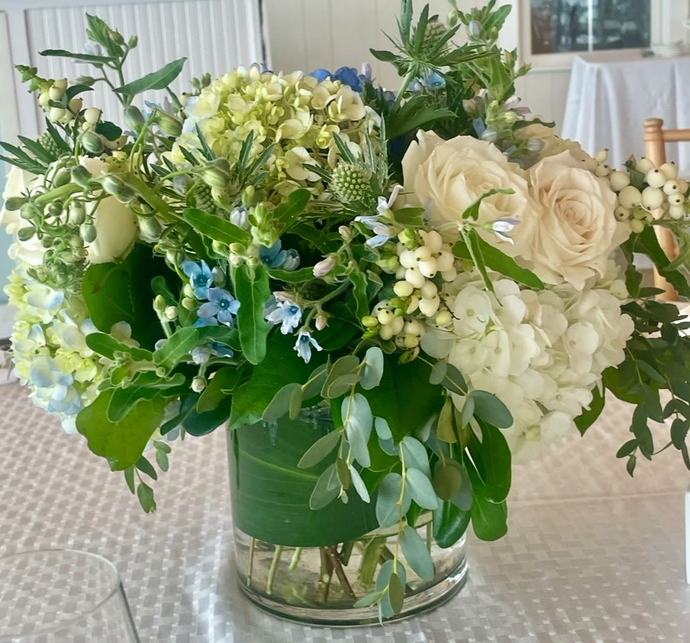 Cape Escape - Hydrangeas, berries, thistle and roses in shades of blue and white in a vase.
