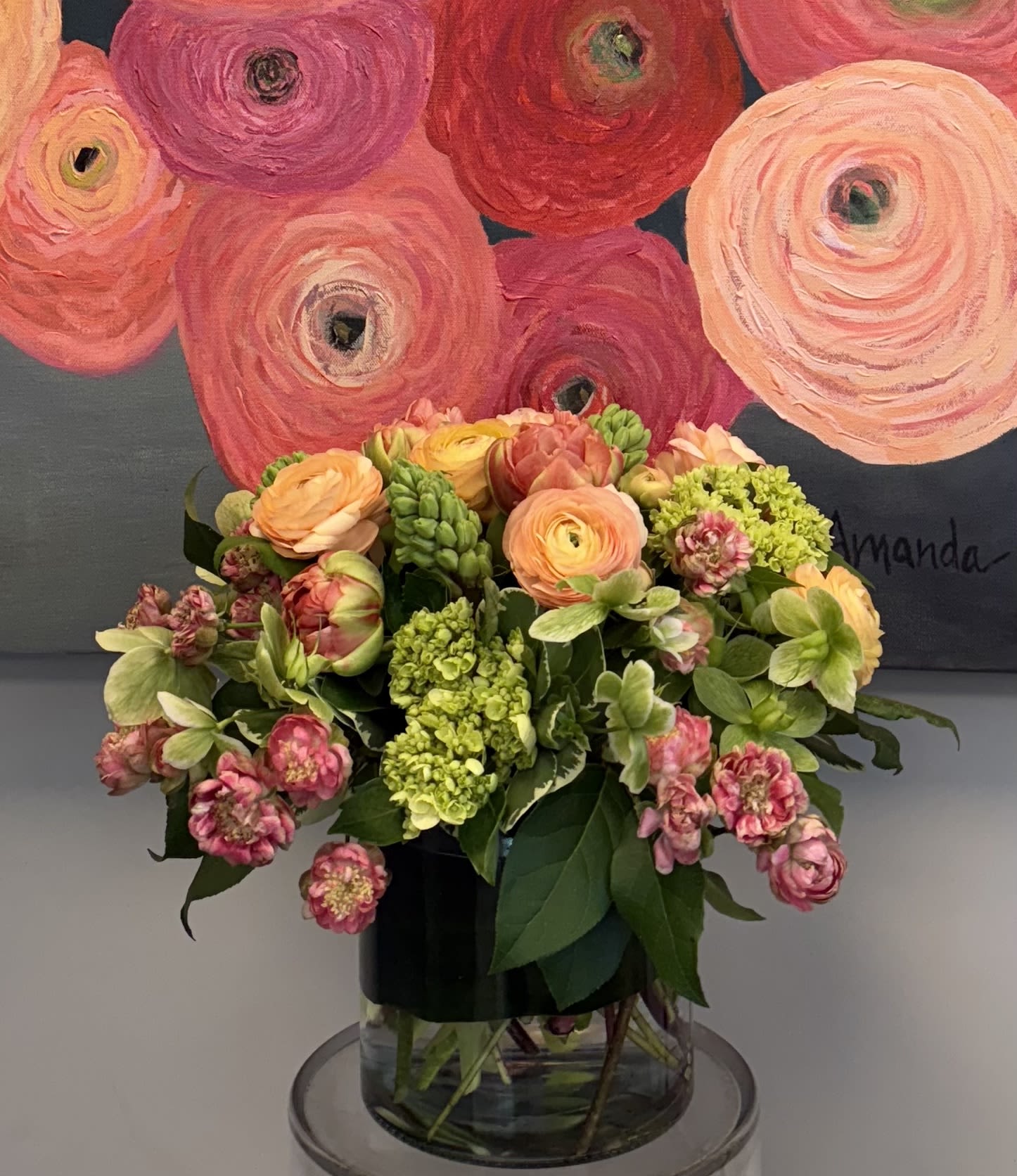 Coral Charm - Ranunculus, hydrangea, hyacinth,spray roses, helebores in a clear glass vase.