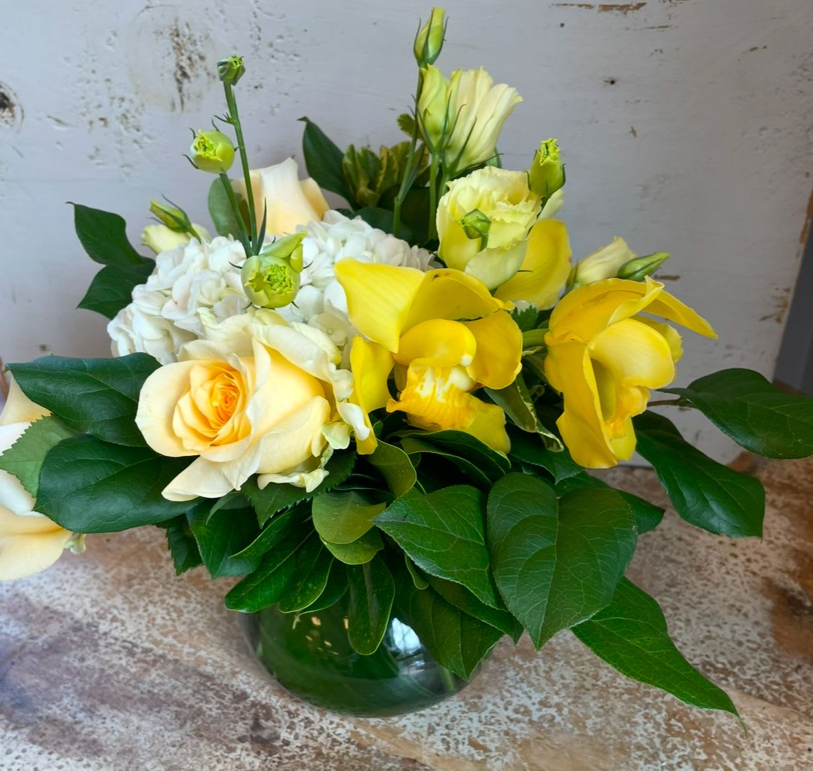 Dream in Yellow - hydrangea, roses, lisianthus and cymbidium orchid in shades of yellow and white in a vase.