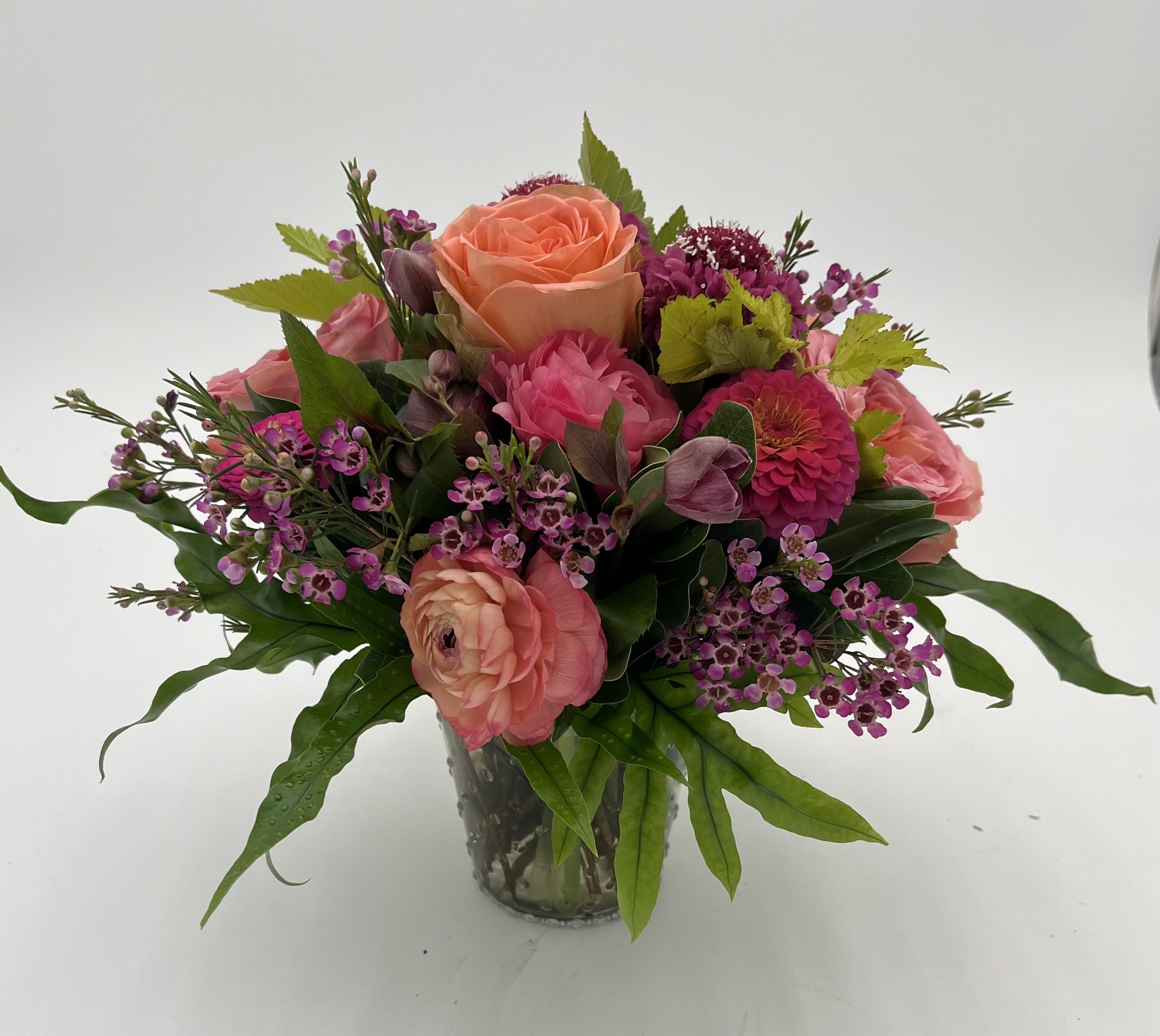 Festivity - Roses, ranunculus, waxflower and scabiosa in a vase.