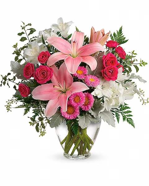 Blush Rush Bouquet - Luxe lilies in a beautifully blushing shade of pink are sure to make them smile, no matter the occasion! This pretty bouquet features hot pink spray roses, pink asiatic lilies, white alstroemeria, pink matsumoto asters, seeded eucalyptus, leatherleaf fern, dusty miller, and pitta negra. Delivered in a Serenity Vase.