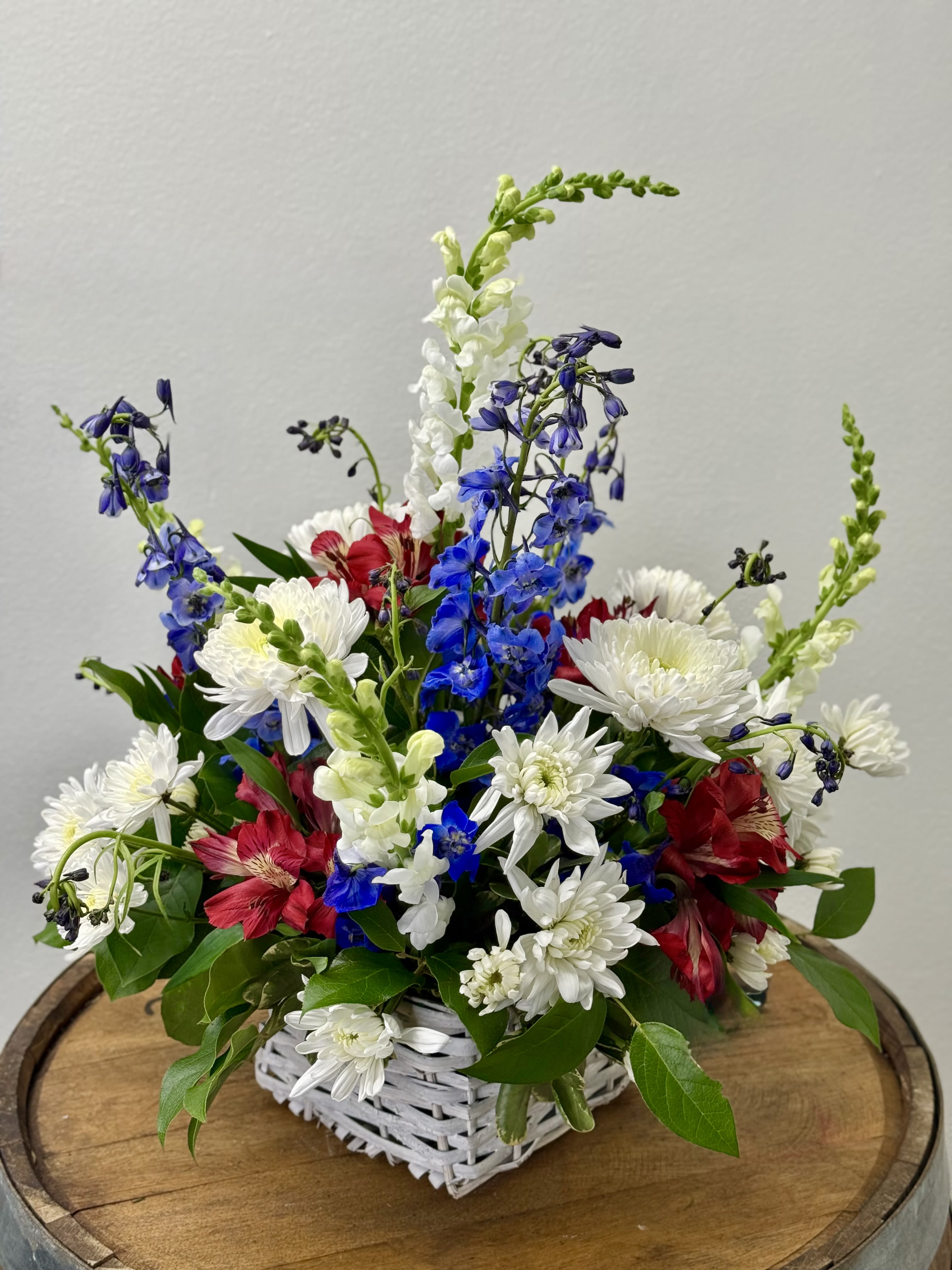 Red, White and Bloom - "A tisket, a tasket, a patriotic basket." A fresh burst of patriotic charm- Red, White and Bloom captures the spirit of summer celebrations with crisp white, bold reds, and vibrant blues. Designed with a light, airy touch and just enough wildness, it feels like sunshine on a front porch and fireworks just waiting to happen.