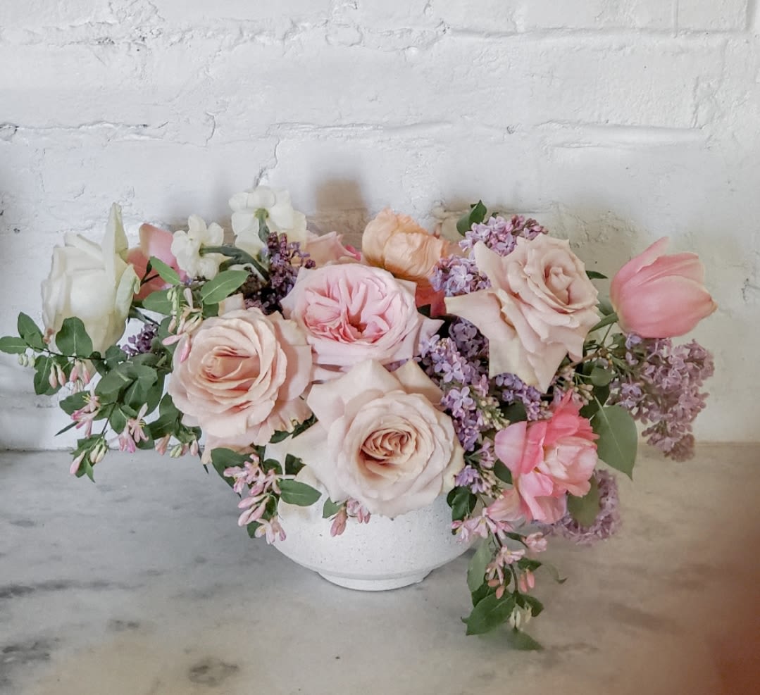 Pastel rose and tulip arrangement in a white bowl vase