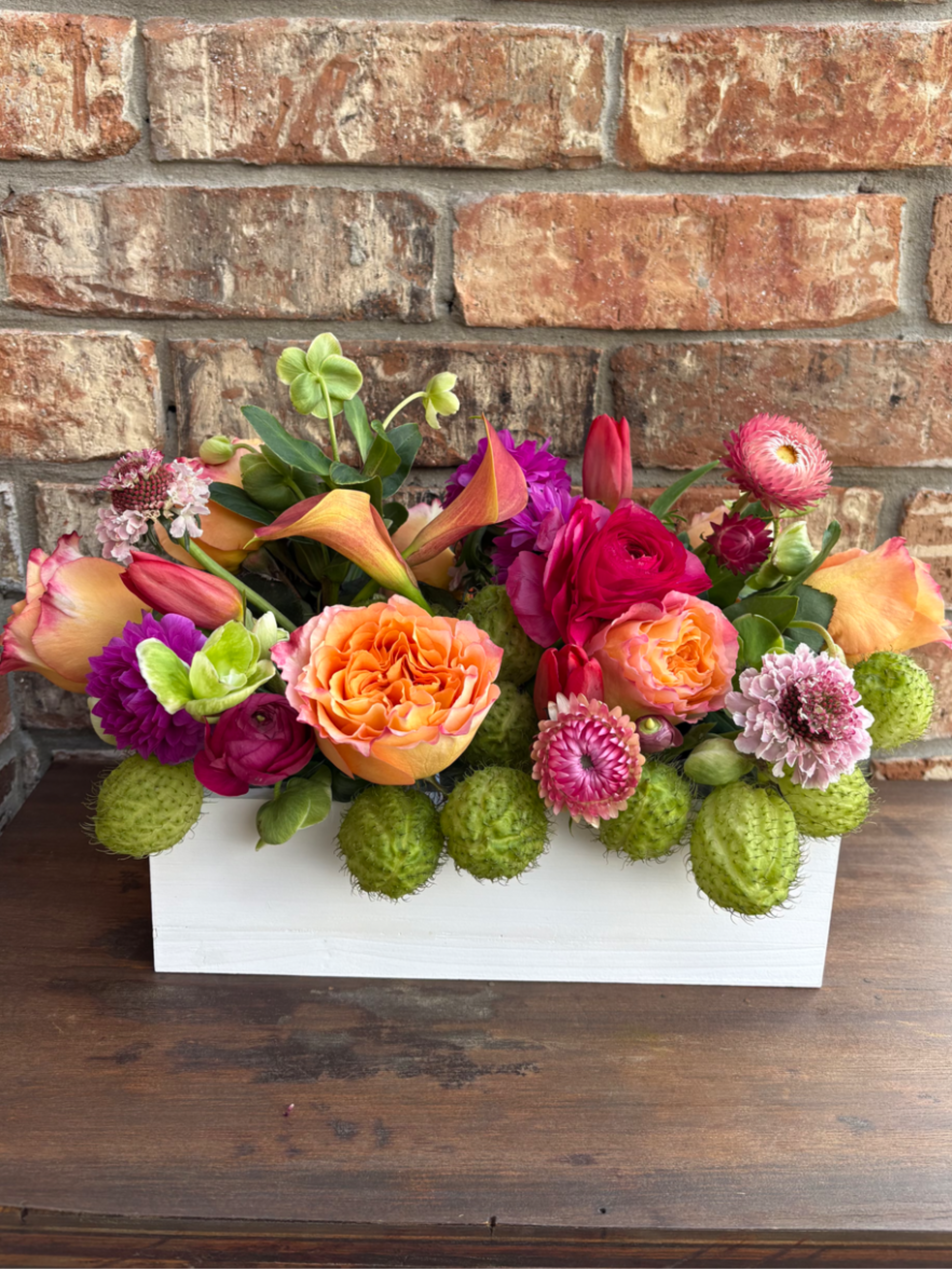 Colorful mixed flower arrangement in a white rectangular box