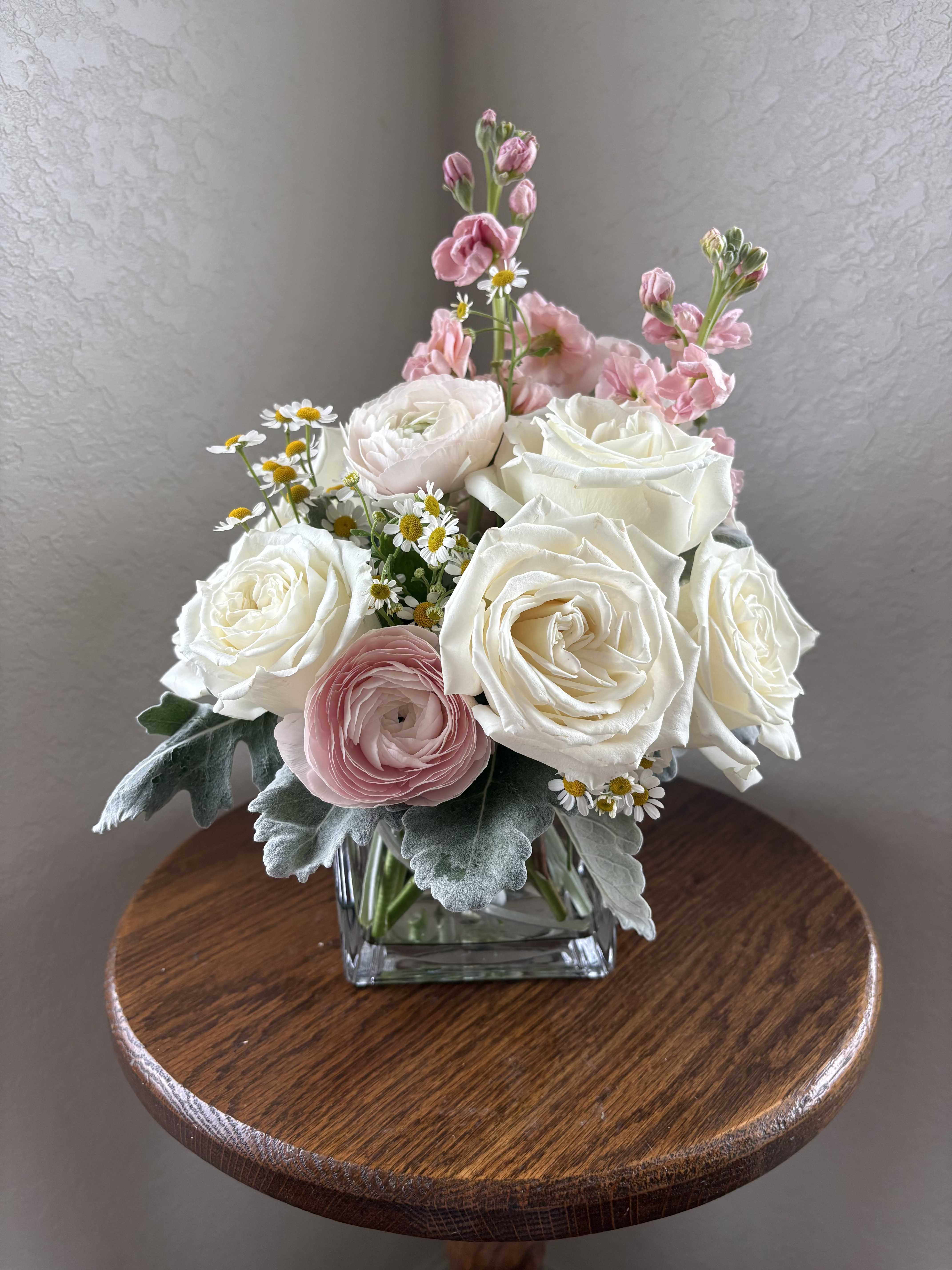 Pink and white rose bouquet in a square glass vase