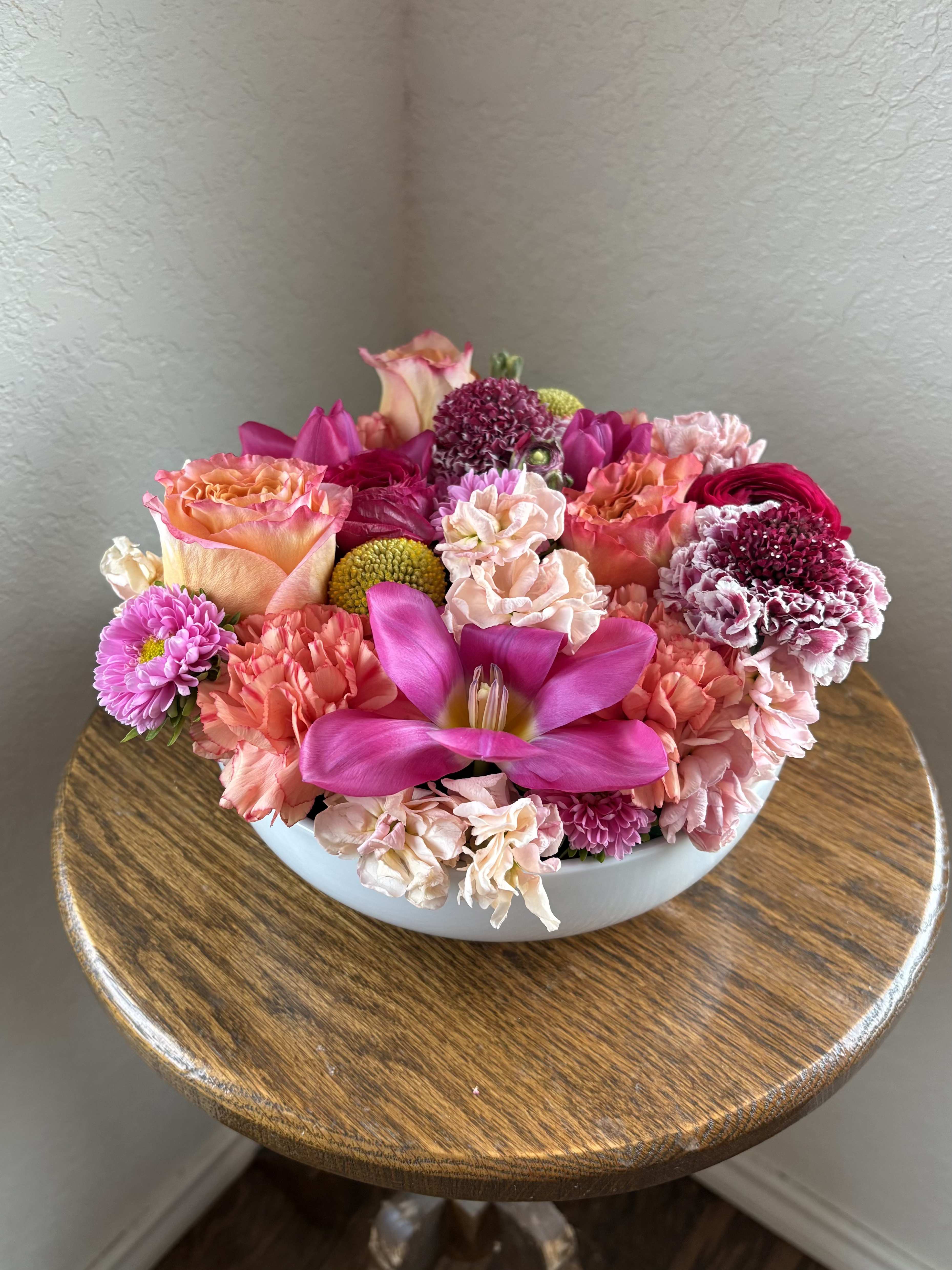 Psychedelic Petals - A cheerful compact arrangement brimming with sunlit yellows, playful pinks, and soft peach tones. Designed in a natural wooden container, this piece brings a warm, boho charm — perfect for brightening any space with a touch of groovy, retro sweetness