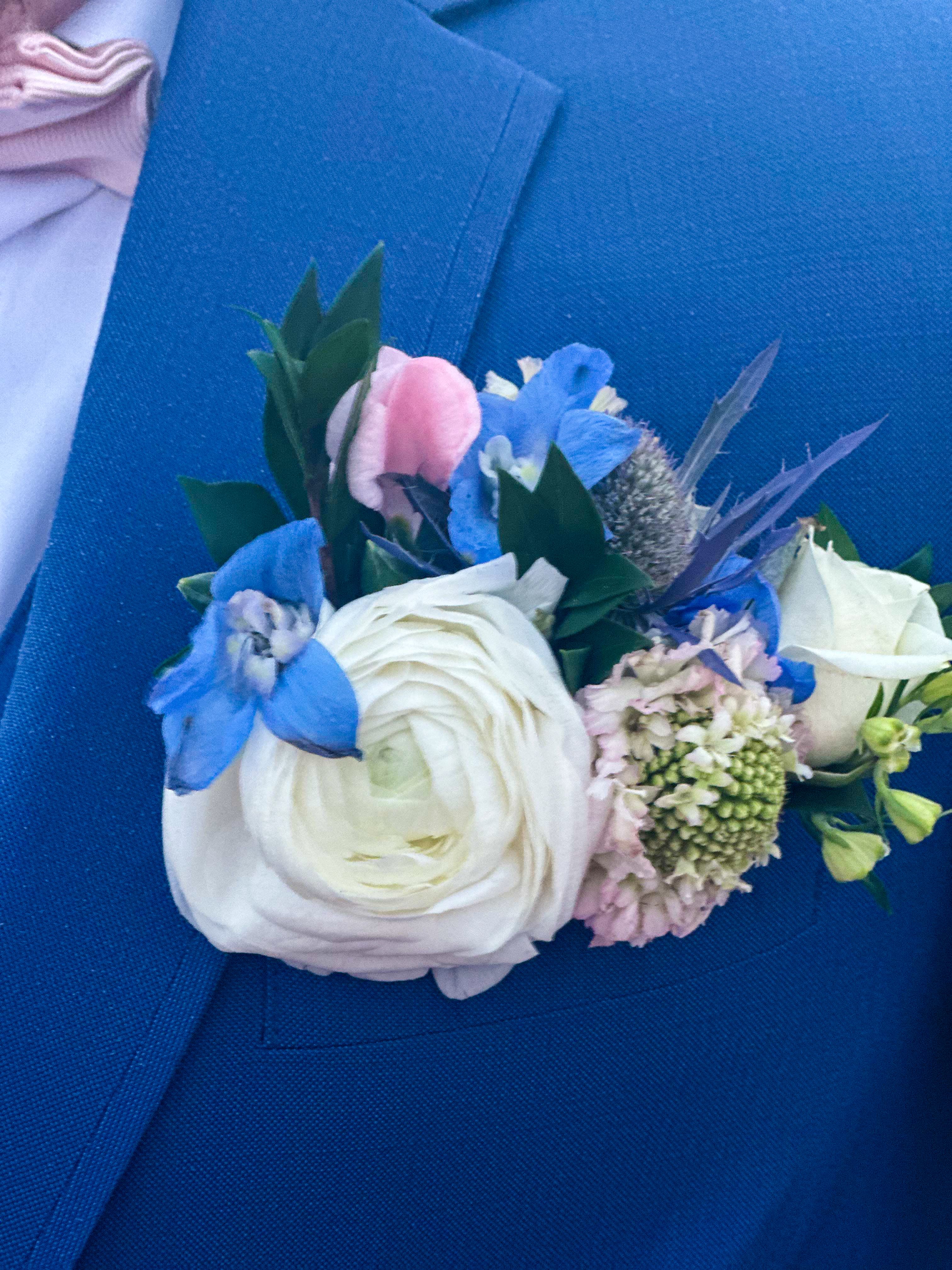 Blue and white boutonniere with a large white bloom
