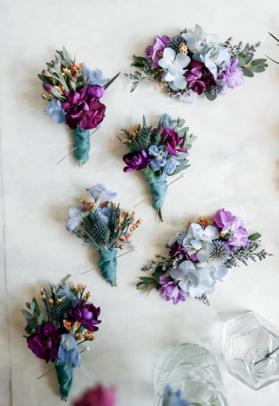 Small purple and blue boutonnieres with wrapped stems