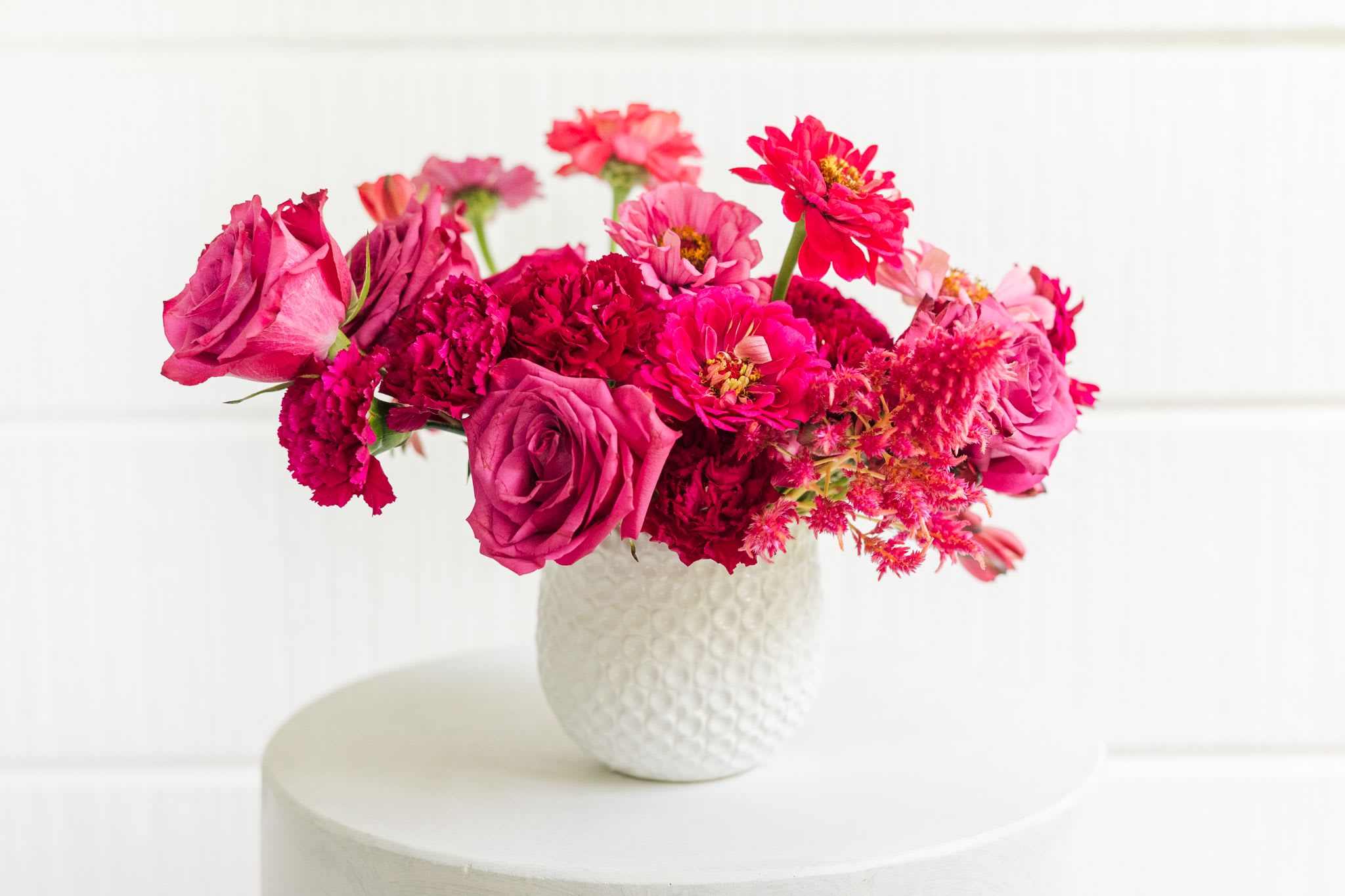 Pink and magenta mixed bouquet in a white textured vase