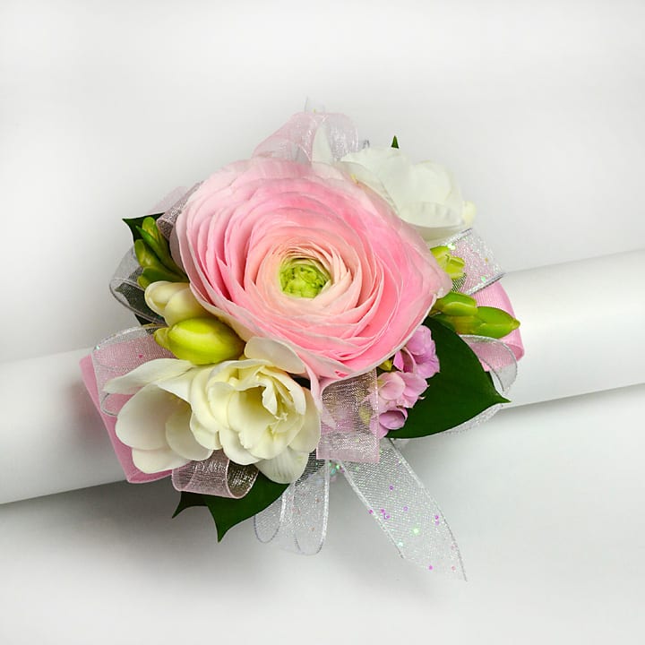 Elegance - wrist corsage  - Delicate pink ranunculus accented with fragrant white freesia makes for a perfect corsage. This is priced for the wrist corsage only. 