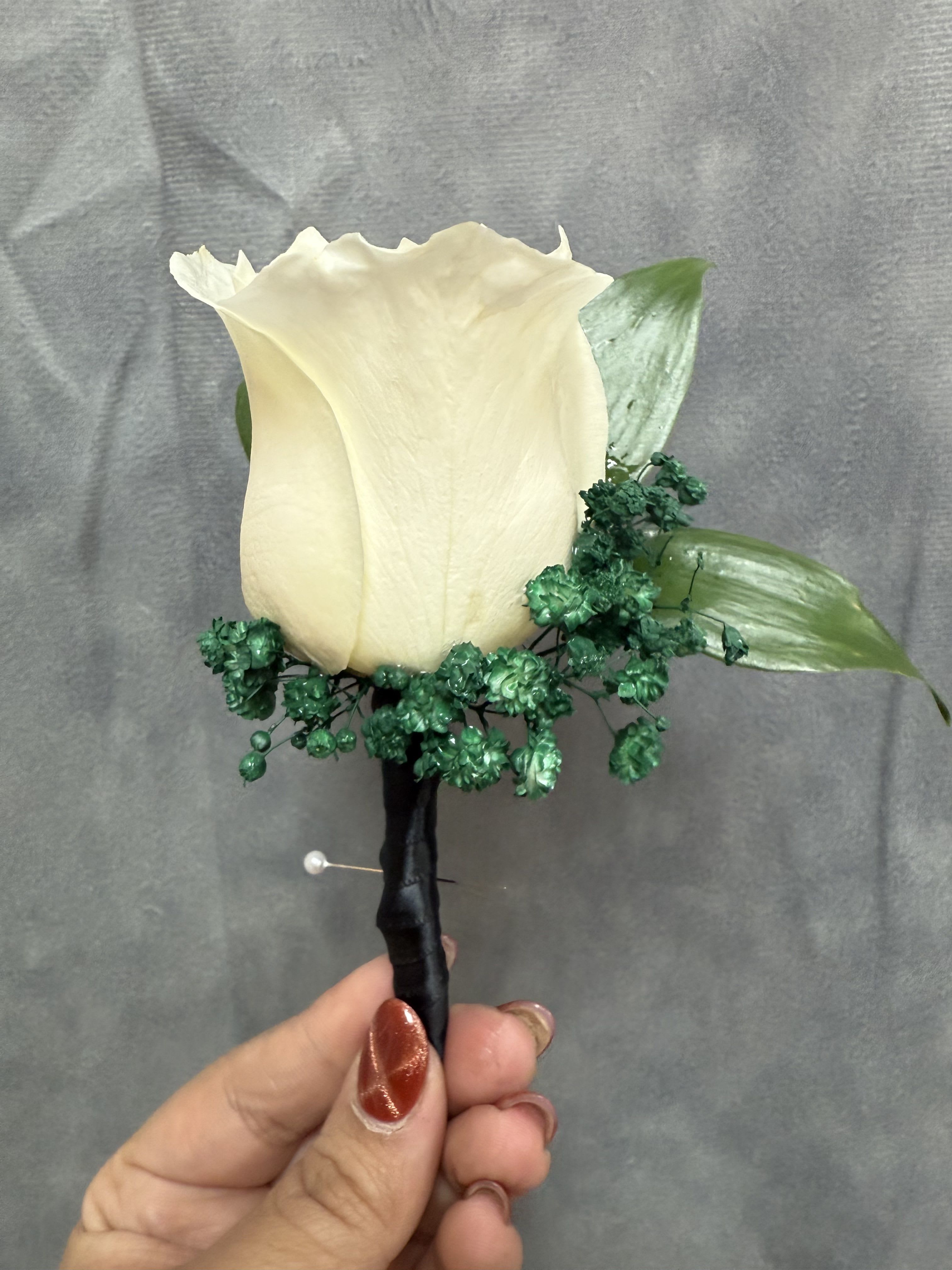 Emerald Green Black White Boutonnière  - White rose with emerald green baby breath boutonnière wrapped with black ribbon 