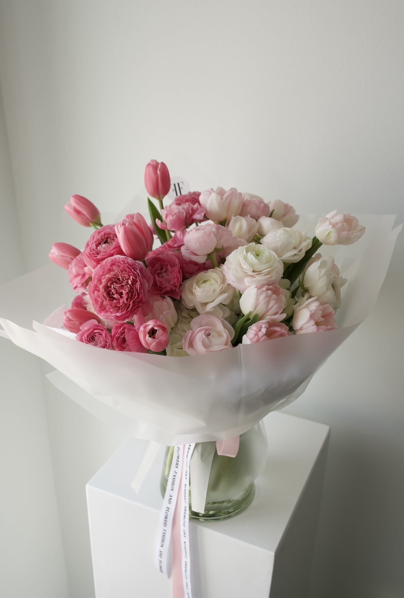 Rosé Volume - A soft, cloud-like bouquet in layered shades of pink and ivory.  Filled with lush ranunculus and tulips, it feels airy, full, and effortlessly beautiful.  Light in tone, rich in texture — like a quiet moment wrapped in petals. 