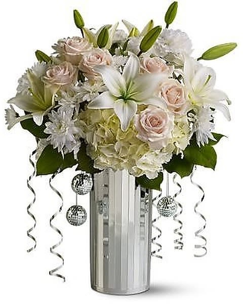 Time Square Flair - Just as Times Square is the place to be on New Year’s Eve, this big, beautiful bouquet will also be the center of attention! With its dramatic arrangement of crème and white flowers set off by tiny mirrored disco balls, dangling silver ribbons and a silver-toned vase, it’s bright, shiny and totally glam. Mirror vase is subject to availability. If unavailable, it will be replaced by similar mirror vase with similar style.