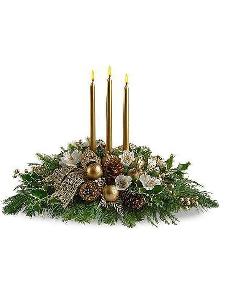 Low centerpiece with three gold candles, white flowers, pinecones, and gold ornaments