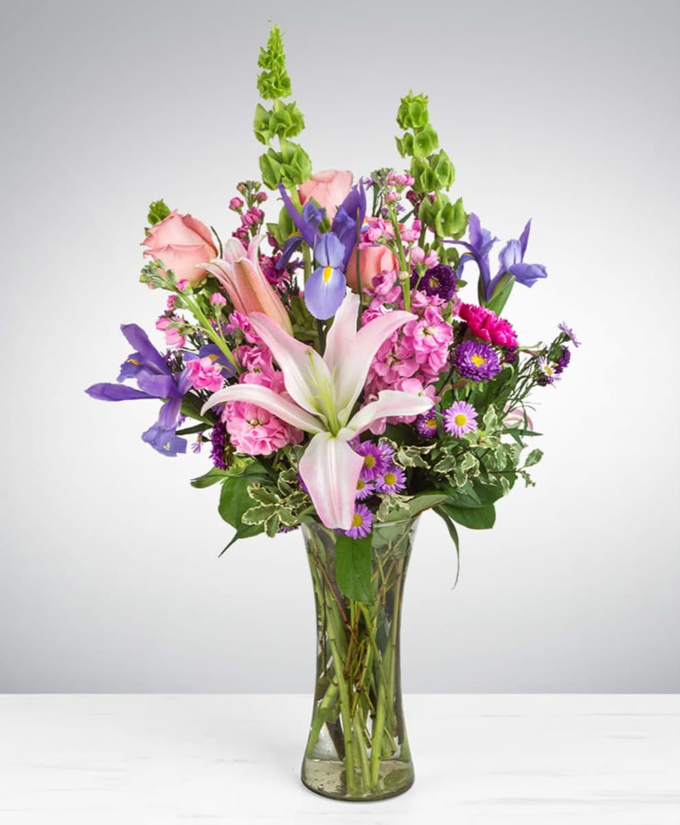 Enchanted Fairytale  - This arrangement contains stargazer lilies, bells of ireland, stock, blue iris, roses, carnations, and purple aster. This is a great gift for birthday, Mother's Day, love and romance, or to say thank you. APPROXIMATE DIMENSIONS: 16" D x 26" H