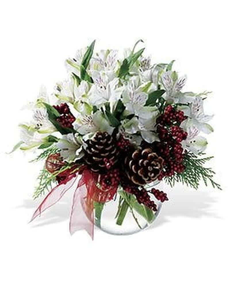 Low arrangement of white flowers with pine cones and red berries in a clear glass bowl vase.
