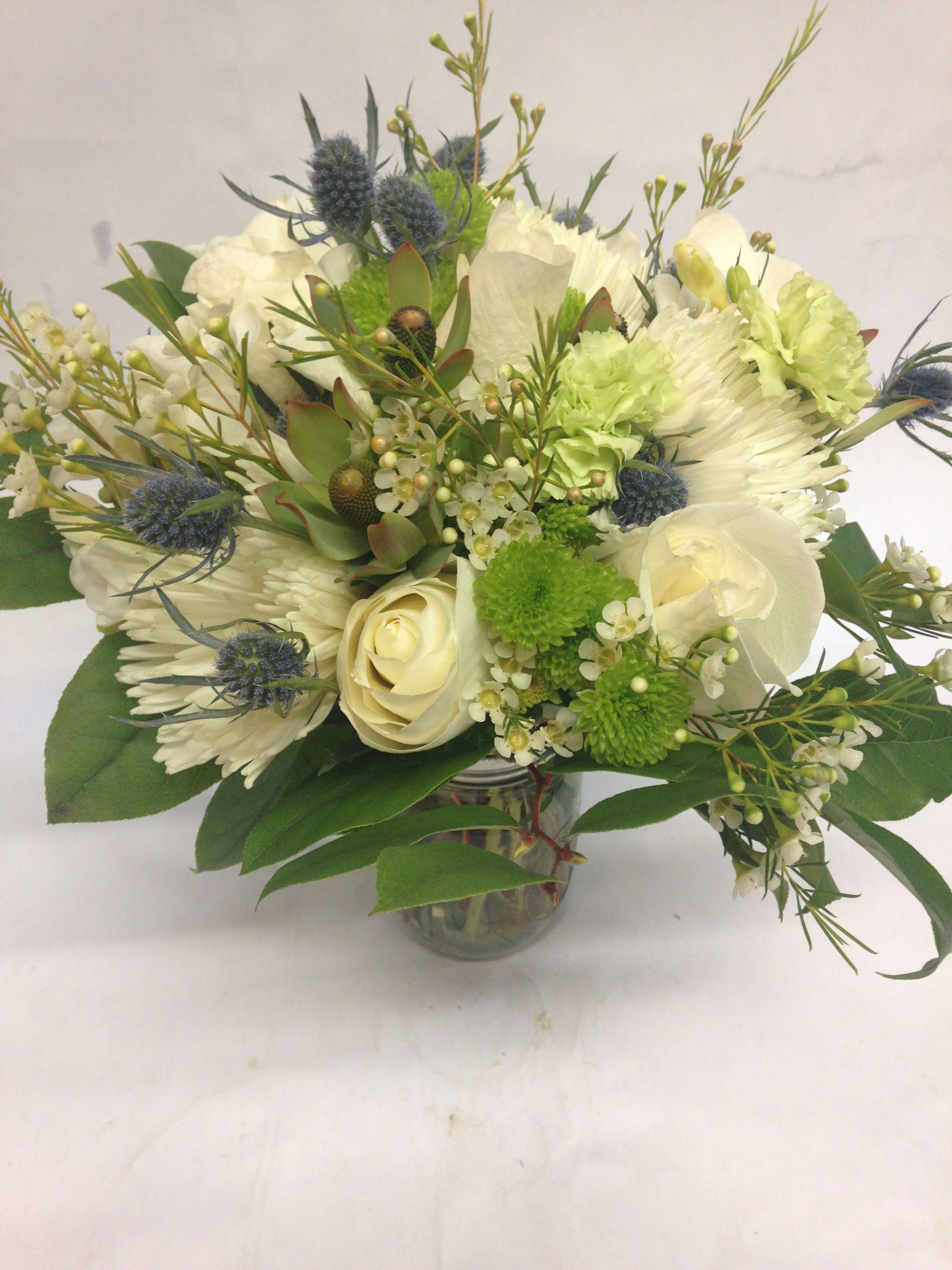 White and green bouquet with roses and chrysanthemums in a glass vase