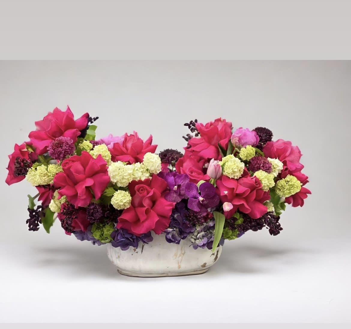 Sally - This bold, jewel-colored mix of blooms includes reflexed Roses, Peonies, Tulips, Hydrangea, and other seasonal flowers
